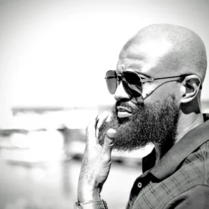 Bearded man wearing sunglasses in a black and white photo.